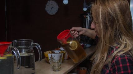 Žena sipa čaj od kamilice u šolju