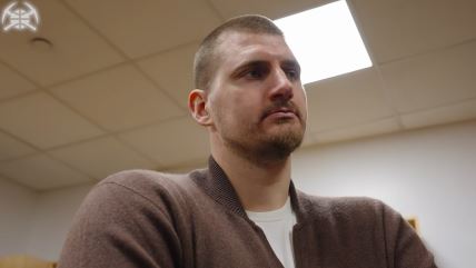 Nikola Jokić u braom kardiganu sluša čestitke.