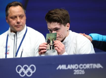 Maksim Naumov pokazuje fotografiju roditelja na Zimskim olimpijskim igrama
