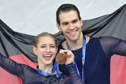 Nikita Volodin sa zastavom Nemačke slavi medalju.