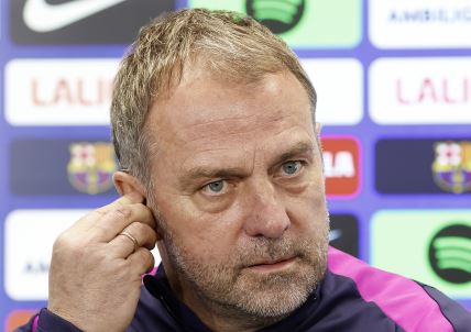 Hansi Flik stavlja slušalicu u uho.