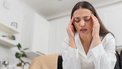 Žena se drži za glavu