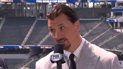 Zlatan Ibrahimović u odelu daje izjavu s mikrofonom.