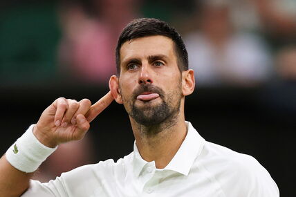 Novak Đoković drži prst na uhu.