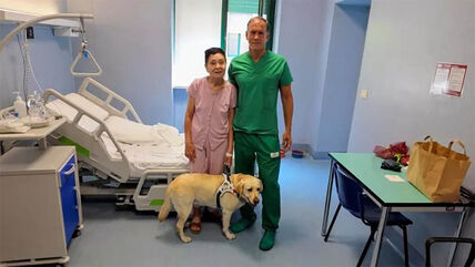Mikele Reibaldi i Elena stoje ispred bolničkog kreveta sa psom