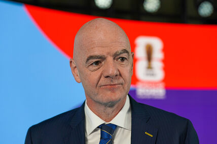 Đani Infantino u odelu sa crveno-plavom pozadinom.