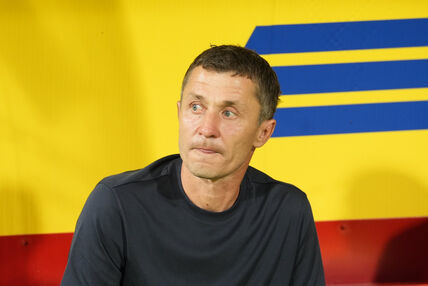 Saša Ilić na klupi Partizana sa žutom pozadinom.