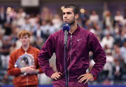 Karlos Alkaraz daje intervju na US Openu dok je iza njega Janik Siner.