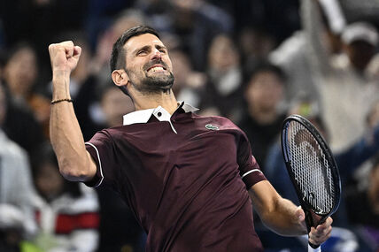 Novak Đoković slavi poen u burgundi majici u Pekingu.