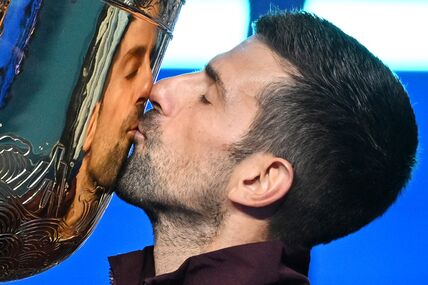 Novak Đoković ljubi trofej osvojen u Pekingu.