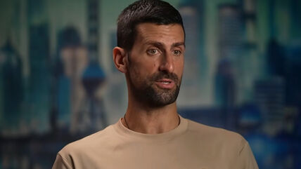 Novak Đoković daje intervju u bež majici.