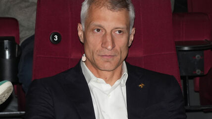Ivan Miljković sedi u odelu u fotelji crvene boje.
