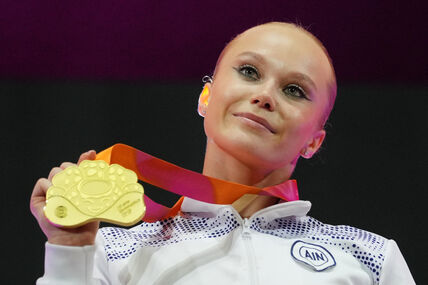 Angelina Melnikova pokazuje medalju na gimnastičarskom takmičenju