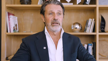 Patrik Muratoglu daje intervju u sakou dok je iza njega polica.