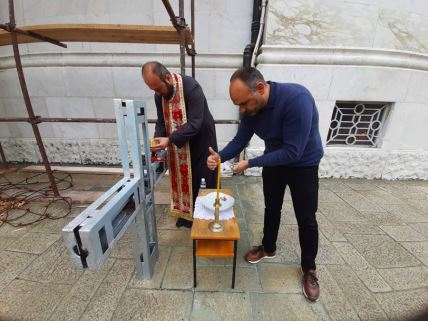 dragan reljic i svestenik pale svecu ispred krsta na oplencu