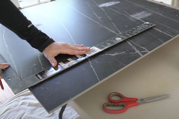 covek sece plocicu za pod