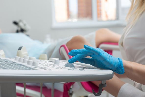 Doktorka sa plavom rukavicom pregleda ženu