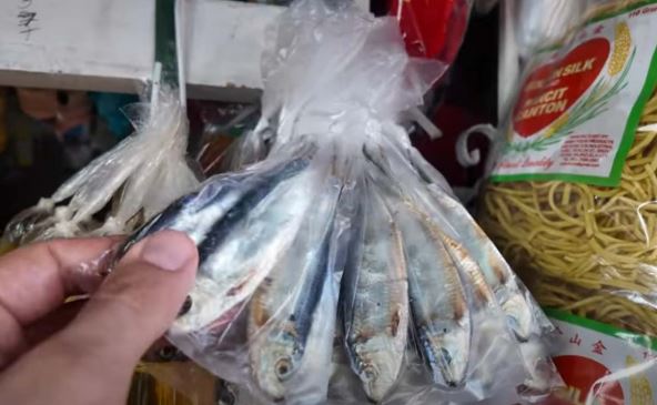 Robert Dacešin pokazuje tri male sardine koje se kupuju u najvećoj faveli Filipina