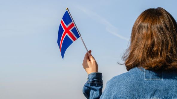 Ženska ruka sa zastavom Islanda koja se vijori
