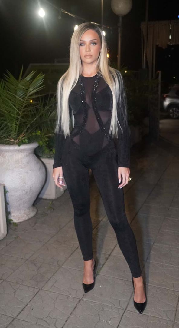 Breskvica sa dugom plavom kosom u crnom kombinezonu