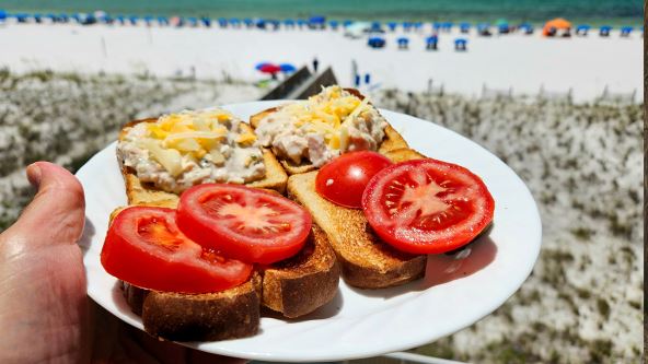 Tost sendvič sa paradajzom u tanjiru na plaži