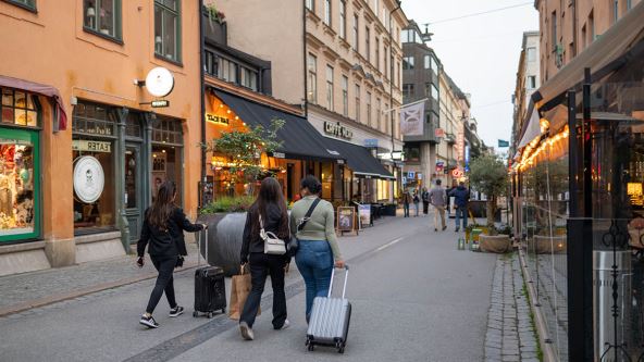 Tri devojke sa koferima šetaju ulicom u Švedskoj