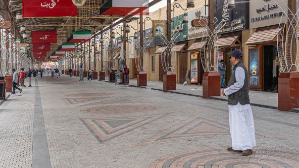Muškarac stoji u ulici sa motivima mozaika u Kuvajtu
