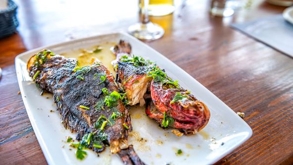 Riba na belom tanjiru u restoranu na ostrvu Ikarila, Grčka