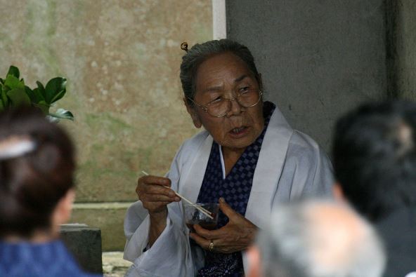 Žena jede štapićima iz staklene činije