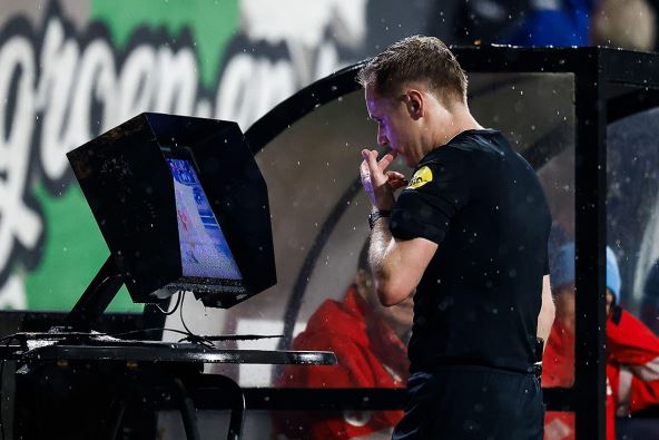 Fudbalski sudija gleda ekran jer se aktivirala VAR tehnologija.