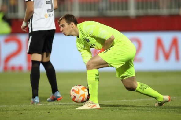 Aleksandar Popović baca loptu u dresu Partizana.