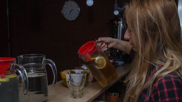 Žena sipa čaj od kamilice u šolju