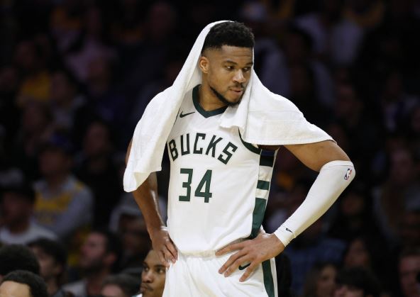 Janis Adetokunpo sa peškirom na glavi gleda u klupu Milvokija