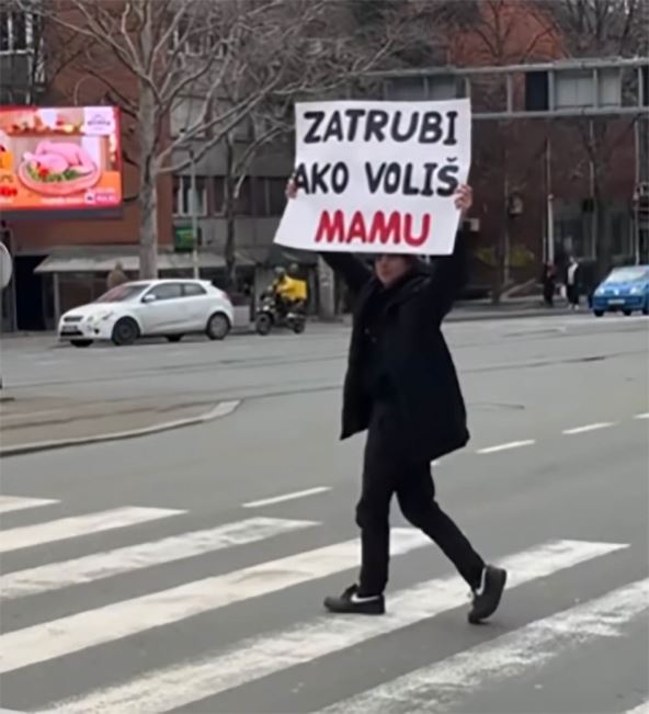Luka Alerić drži plakat na ulici Beograda