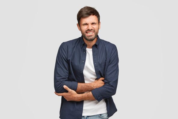 attractive-young-bearded-male-suffers-from-terrible-stomachache-crosses-hands-clenches-teeth-with-pain-ate-some-spoiled-products-being-ill-isolated-white-wall-problems-with-health.jpg