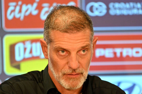 Slaven Bilić u crnoj košulji dok su iza njega reklame.