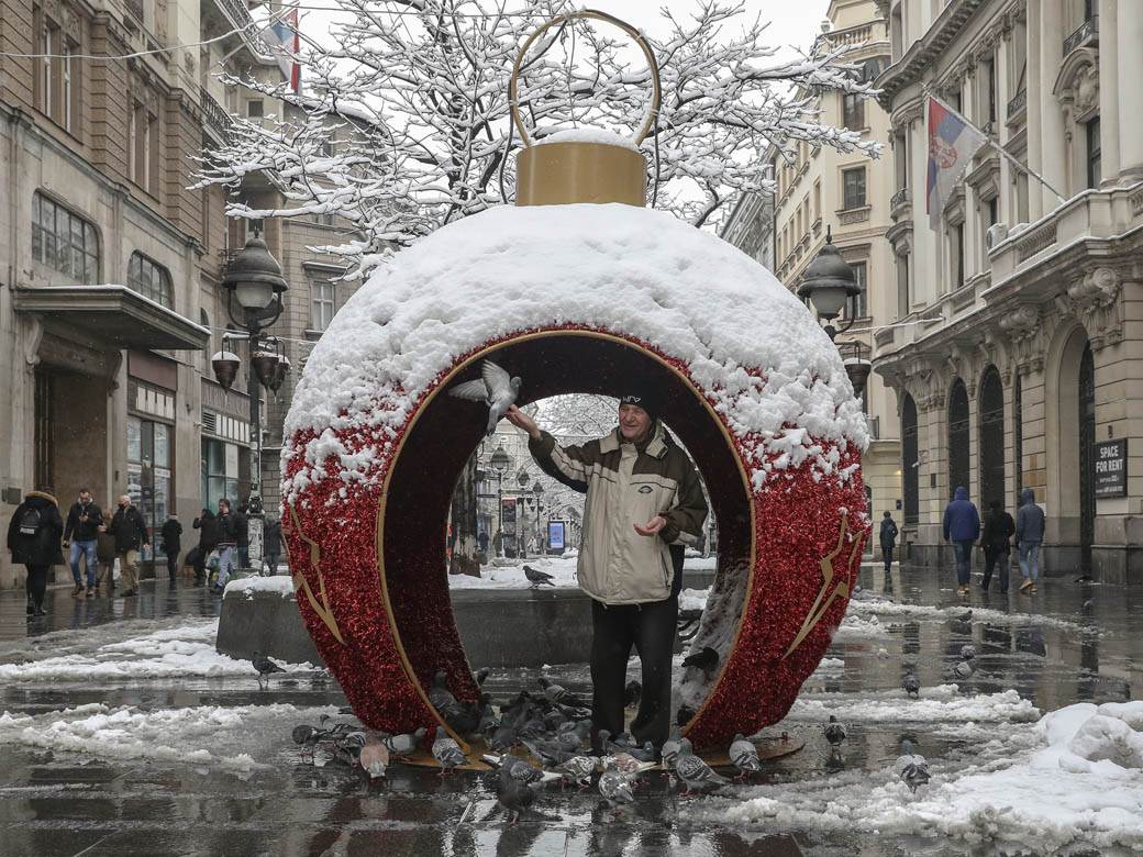 covek hrani golubove u beogradu sneg zima ulica ljudi fotografije