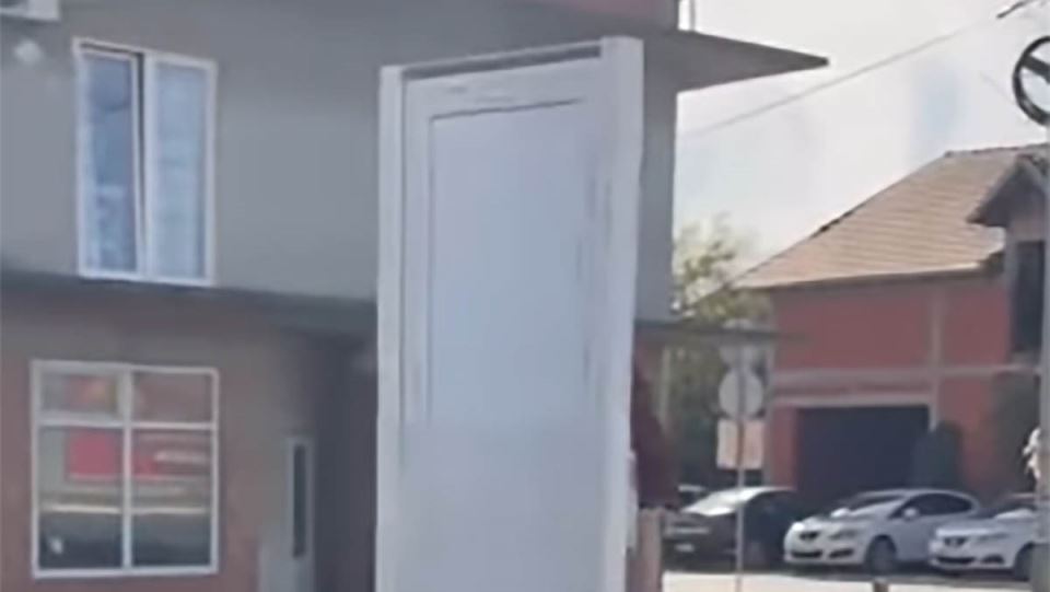 čovek vozi vrata na trotinetu kroz Surčin (1) copy.jpg