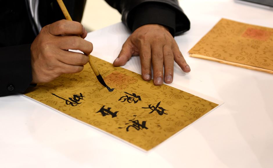 Profesor iz Kine na beogradskom Sajmu knjiga poklanjao prisutnima kaligrafska pisma sa njihovim imenom.