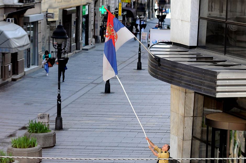 Zastava Srbije - Radnik isprvlja umotanu zastavu oko barjaka